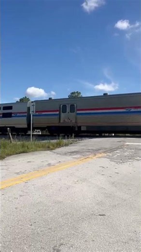 Fast Amtrak train speeding past crossing (archive)