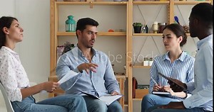 Four multi ethnic company staff take part in briefing sit in circle talking, discuss current task, work on collaborative project share thoughts, solving business. Teamwork, group meeting event concept