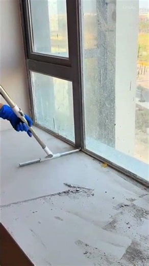 Removing dust and debris from the windowsill with a long handled squeegee for a clean surface now
