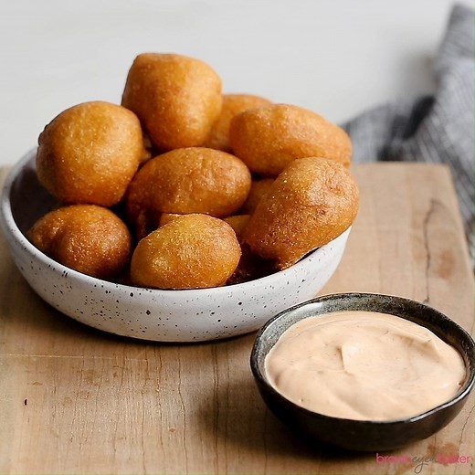Hush puppies are crispy and golden on the outside with a soft, cornbread interior and served with an irresistible spicy dipping sauce made from only THREE ingredients!!! Recipe--> https://www.browneyedbaker.com/hushpuppies-with-spicy-dipping-sauce/ | Brown Eyed Baker