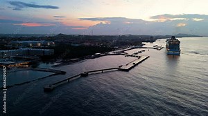 Cruise ship docks at historic Caribbean port town at sunset