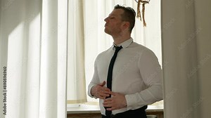 hoose elegant men's business clothes. Fitting room man.Man tries on clothes in a store. In a beautiful white shirt and tie.