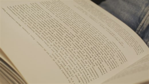 A woman gently turning the pages of a book - Free Stock Video