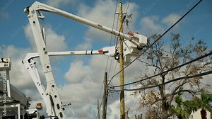 Utility workers fixing a power line after a massive hurricane.