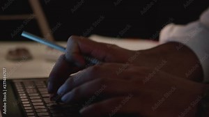 Man Works Late in Dark Office at Night, Types on Computer, Pan Face to Keyboard