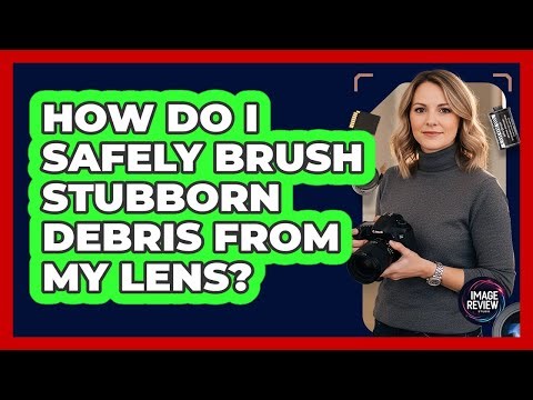 How Do I Safely Brush Stubborn Debris From My Lens?