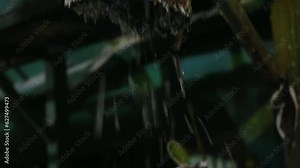 Shredded multi-colored garbage pours out of a rusty metal pipe into a white waste bag for disposal. Inside waste recycling plant, care for the environment
