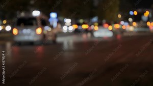 Slow moving cars night city road. Blurred transport traffic night. A frame in the out-of-focus of a car driving along a city road at night. The light of car headlights in the night. 4k footage