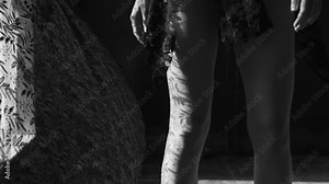 Closeup woman's legs wearing red wedges walking. Girl in sandals on platform with lace curtain shadow and sun rays on her legs - black and white video in slow motion