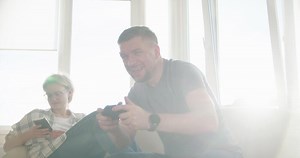 Couple Sitting on the Sofa and Playing Games, Using Controllers in Love have Fun Playing in Online Games Together. Slow motion