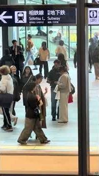Couple lost looking down smartphone for direction at Yokohama station
