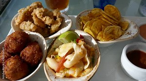Seafood appetizers with conch fritters, calamari, ceviche, and fried banana chips
