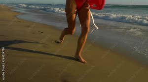Female lifeguard running along the beach Stock Video