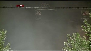 Firefighters watch adjacent silo after explosion at recycling plant