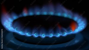 Methane igniting with blue fire on a kitchen gas stove in dark room. Interior of an apartment and house equipment. UHD