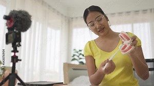 asian woman using toothbrush cleaning a mock up teeth and mouth. Dental teaching by video online e learning.
