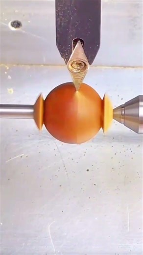 Lathe shapes sphere, tool carves smooth symmetry