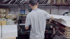 man prints on printing press company's logo on packaging products