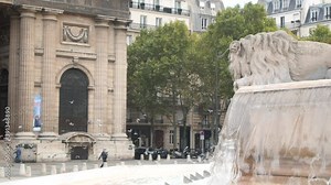 Classical French fountain in Paris with pigeons flying in the background