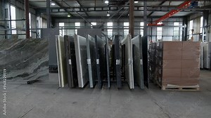 Colorful quartz and porcelain tile stone slab are standing in the factory warehouse. Kitchens and bathrooms countertop selection. Granite slabs are prepared for sale in store yard