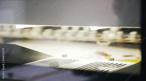 Insides of an industrial printer during its work at a printing plant. Locked down real time close up shot