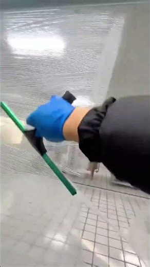 Using a squeegee to perfectly clean a glass door in a laboratory
