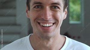 Close-up face of a man pleasantly surprised. Portrait of a surprised happy man, shows positive emotions. The male rejoices and smiles closeup