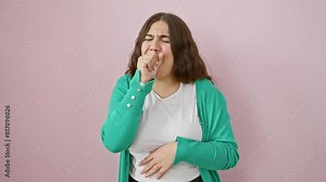 Young, beautiful hispanic woman, visibly unwell and coughing over isolated pink background, as she bravely battles bronchitis. a poignant portrait of health care struggle. Stock Video