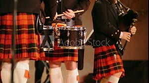 Traditional scottish band musicians singing with bagpipes and drums on the stage