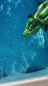 funny footage of a inflatable green crocodile swimming pool toy floating on the clean pool waves surface. Summer vacation concept 4K vertical footage for mobile devices usage
