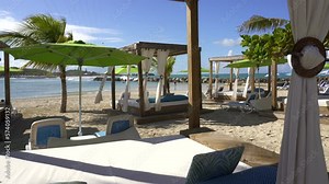 Beach cabanas overlooking the Caribbean Sea. Relax in the shade. Beach, sand, umbrellas, loungers, curtains, palm trees, beach beds. Adrenaline Beach, Labadee, Haiti private resort by Royal Caribbean. Stock Video