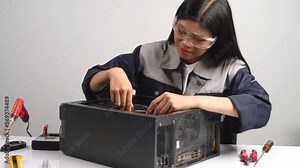 Young female technician repairing computer in the service center. Service concept for repair and maintenance of electronic devices.