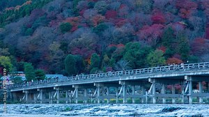 A dusk timelapse of Togetsukyo bridge in Kyoto in autumn telephoto shot zoom
