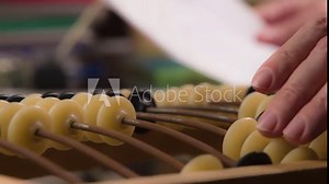 Man Uses Vintage Old Abacus. Close-up of male hands doing abacus count and checking notes