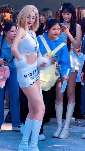 blonde bombshell is dancing wildly in the street; her figure and looks are absolutely stunning!