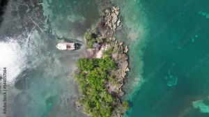 Epic island in a caribbean coast with vegetation and stunning depth and water color, with an old abandoned boat, impressive aerial view
