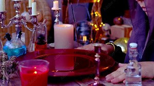 red dish with water, candle lights in dark room of future fortuneteller, esoteric Oracle, session of magic, divination for the future, activity at halloween party, prophecies from the world of spirits