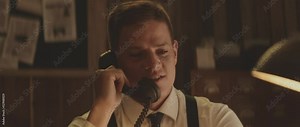 Man in white shirt having phone call, using office telephone. Retro style detective using deduction for solving challenging cases.