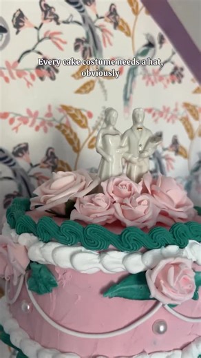 Every cake costume needs… a hat! 🎂 So I made one with spackle “frosting,” vintage roses, and a wedding cake topper (because apparently this cake is also getting married 💒). It’s ridiculous, it’s adorable, and it makes me laugh every time I see it. Stay tuned—next up is the full cake costume reveal, and it’s extra in all the best ways! 🎀 | At Home with Ashley