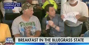 Fox & Friends quickly cuts to commercial after restaurant patron holds up "Fox lies" sign on air