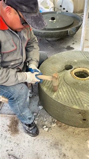 Carving stone grooves using a hammer and a chisel to create a traditional stone mill tool