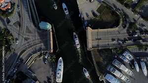 01 Overhead aerial view of boat traffic crossing elevated river bridge in 4K
