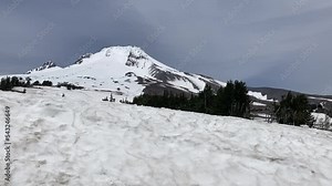 View of the ski slopes of Mt Hood late in the season and the snow-capped peak of the mountain. The chair lift is visible in the distance - Mt Hood, Oregon, USA
