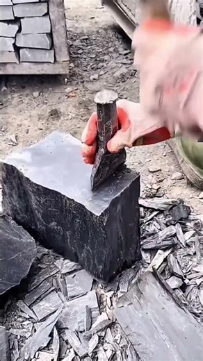 Splitting Black Stone Blocks Using Chisels For Professional Detailed Masonry Architecture Job