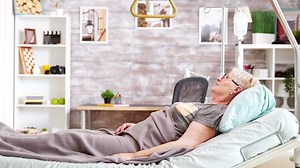 Old lady lying on hospital bed in nursing home. Bright and cozy room