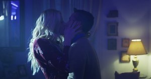 Cinematic shot of carefree happy romantic homosexual female gay and transgender man couple in love is enjoying time together is hugging and kissing with passion as sign of timeless forever love.