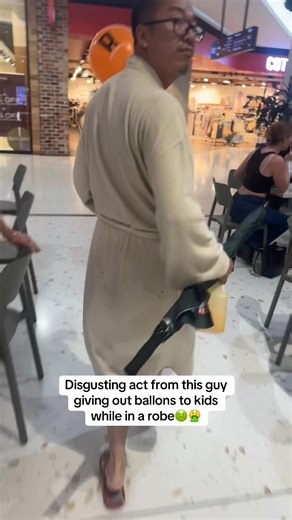 Man in Robe Distributing Balloons to Children at Top Ryde