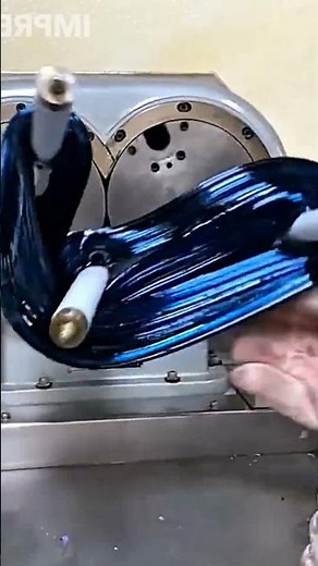 A machine stretching a large mass of blue, hard-boiled candy