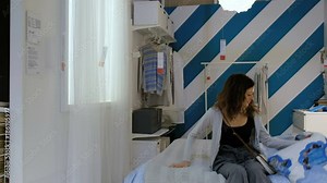 Beautiful Caucasian girl chooses a bed and mattress in a furniture shop, sits on the bed 4K.