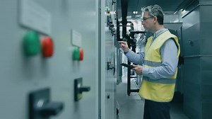 Engineer Factory Worker Programming Setting Up Machinery on a Power Station.